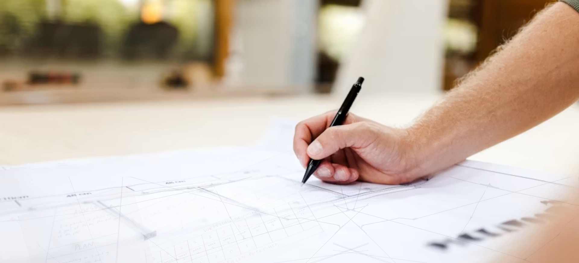 A hand drawing on architectural plans with a pencil