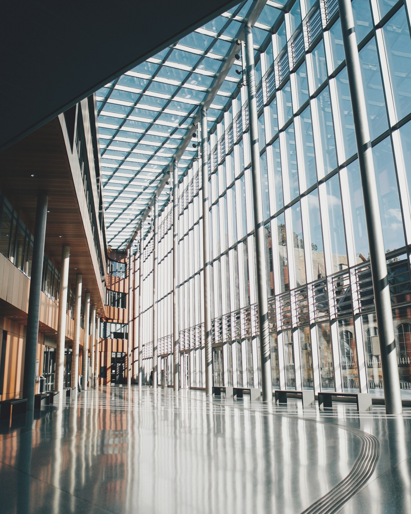 A glass and steel architectural corridor with a skylight