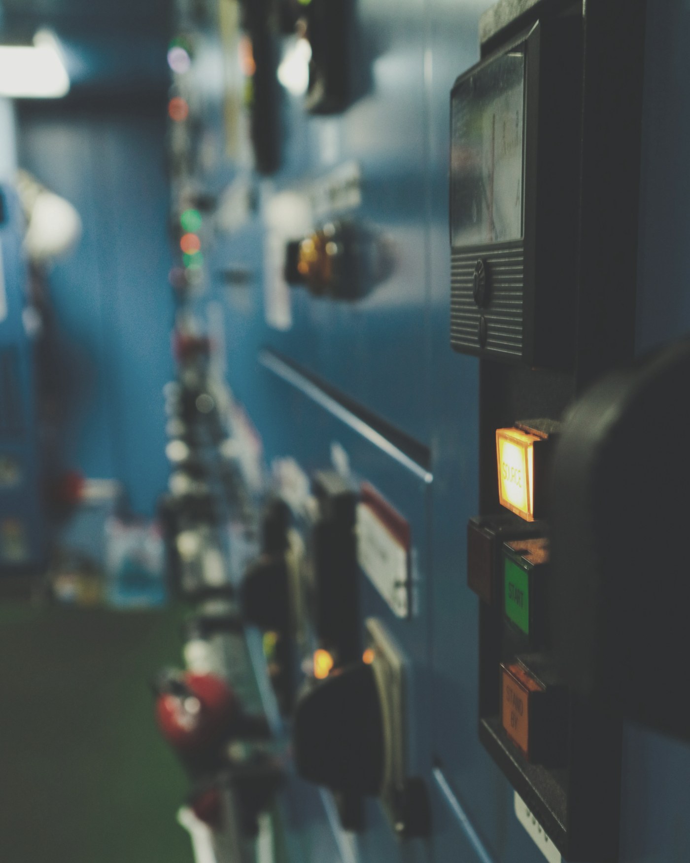 A control room panel with illuminated dials and switches