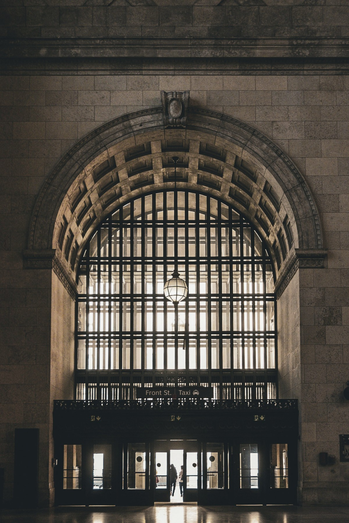 A grand archway entrance, with a figure walking through the doorway